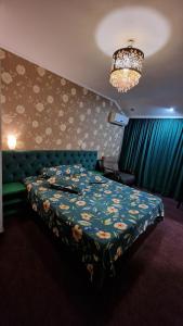 普洛耶什蒂托马膳食公寓酒店的一间卧室配有一张床和一个吊灯