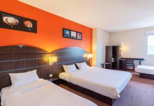 卡斯特尔库里埃尔B&B HOTEL Agen Castelculier的酒店客房设有两张床和橙色的墙壁。