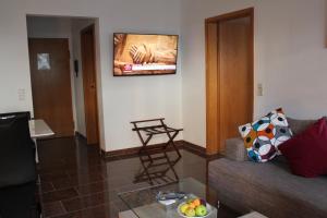 罗拉赫费恩渥诺沃提尼酒店的客厅配有沙发和墙上的电视