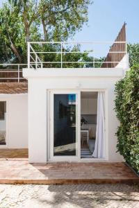 卡帕里卡海岸Hoso Loft 24 Beach House的白色的房子,设有大玻璃门