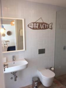 卡帕里卡海岸Hoso Loft 24 Beach House的浴室设有水槽,墙上挂有鱼标