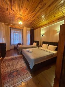 伊斯坦布尔NarPera Taksim Boutique Hotel的一间卧室设有两张床和木制天花板