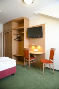 盖布利茨罗斯纳酒店的客房设有书桌、两把椅子和电视。
