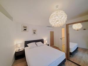 兰斯Antibes, duplex lumineux的卧室配有一张白色大床和镜子