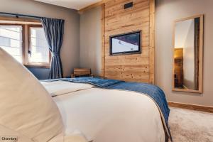 瓦勒迪泽尔阿万谢酒店的卧室配有一张床,墙上配有电视。