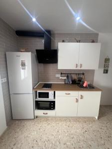 巴尔巴特Apartamento El Faro的厨房配有白色橱柜和白色冰箱。