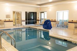 诺福克诺福克奥多明尼奥大学春季山丘套房酒店的游泳池,带桌椅的房间