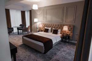 基希讷乌Time Hotel&SPA的一间卧室配有一张大床和一张桌子及椅子