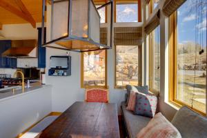 特柳赖德Telluride Mountain Chalet with Gym, Hot Tub and Views!的客厅配有木桌和一些窗户。