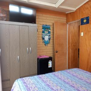 科金博Hostal Los Nogales的一间卧室配有一张床和一台平面电视
