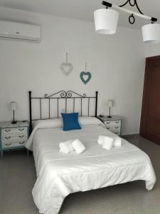 MontielVivienda turística María de Padilla的卧室配有带蓝色枕头的大型白色床