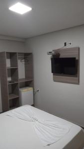 Pasto da MataPOUSADA TAHITI的卧室配有一张床,墙上配有电视。