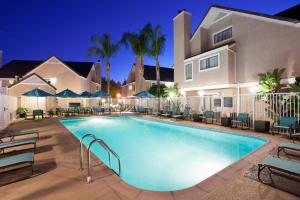 尔湾欧文光谱住宅酒店的夜间在房子前面的游泳池