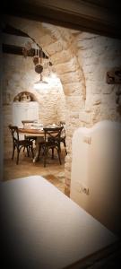 阿尔贝罗贝洛Trullo del Vescovo的一间设有桌子和石墙的用餐室