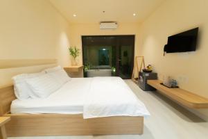 河内Khách sạn Gấu Hotel的卧室配有一张白色大床和一台平面电视。