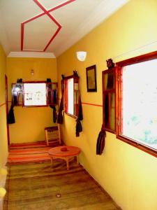 IjjoukakAuberge Tigmmi N'Tamazirte的一间黄色墙壁、一张桌子和一扇窗户的房间