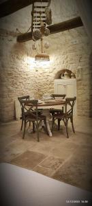 阿尔贝罗贝洛Trullo del Vescovo的一间带木桌和椅子的用餐室