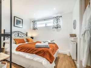 Southwick2 bed property in Bradford-on-Avon 87056的一间卧室配有一张带橙色毯子的床