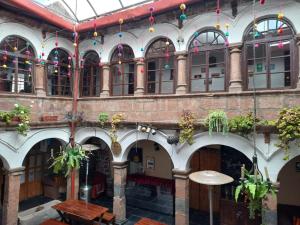 库斯科殖民地皮瓦背包客旅舍的一座大建筑,有桌子和盆栽植物