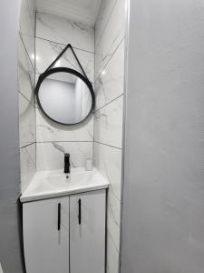德班Vusi's Guesthouse的白色的浴室设有镜子和水槽