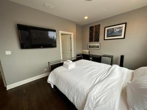 芝加哥Wrigley Penthouse with Private Roof Deck and Parking的卧室配有白色的床和平面电视。