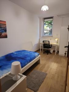 热舒夫Przytulne pokoje u Julii的一间卧室配有蓝色的床和一张书桌