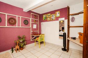 帕纳哈切尔Casa Amaranto的紫色墙壁、桌子和书桌的客房