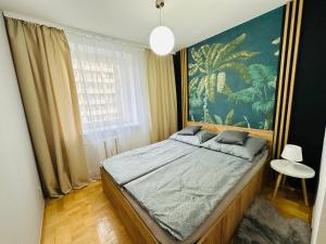 弗罗茨瓦夫New York Style Apartament 90 m2 we Wrocławiu的卧室配有一张大床,墙上挂有绘画作品