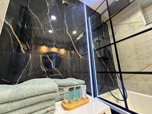 弗罗茨瓦夫New York Style Apartament 90 m2 we Wrocławiu的带淋浴、镜子和毛巾的浴室