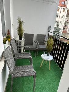 弗罗茨瓦夫New York Style Apartament 90 m2 we Wrocławiu的绿地阳台配有桌椅