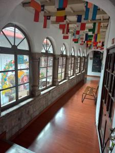 库斯科殖民地皮瓦背包客旅舍的客房设有窗户,天花板上悬挂着色彩缤纷的旗帜