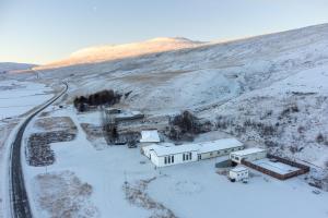 SkjöldólfsstaðirHotel Studlagil的雪中房屋的空中景观