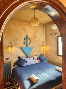 梅尔祖卡骆驼之家住宿加早餐旅馆的卧室配有蓝色的床,墙上挂着蓝色的锚