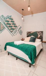 帕纳哈切尔Casa Amaranto的一间卧室配有一张带绿毯的床