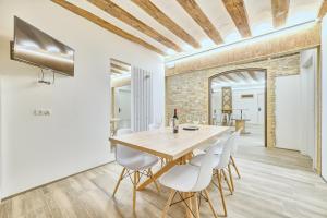 潘普洛纳Casa Bidaiari by Clabao的一间带木桌和白色椅子的用餐室