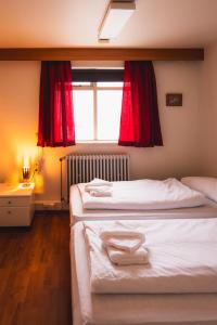 SkjöldólfsstaðirStudlagil INN Hostel的一间卧室设有两张床,窗户配有红色窗帘
