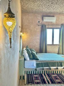 梅尔祖卡骆驼之家住宿加早餐旅馆的一间卧室设有一张床和一个窗口