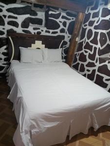 奥兰太坦波Sacred Point的一张带白色床单和枕头的床