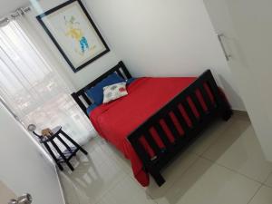 特鲁希略A minutos del centro Con cochera的一间卧室配有一张带红色毯子的床和窗户。