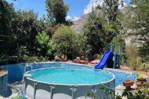 圣阿方索Acogedora cabaña entre montañas的花园内带滑梯的游泳池