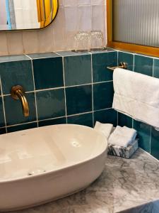 圣路易斯波托西Casa H Hotel Boutique的浴室设有白色浴缸和蓝色瓷砖墙。