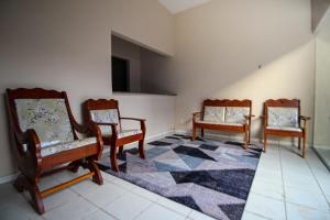 圣路易斯Hotel e Hostel da Fonte的一间房间,配有三把椅子和地毯