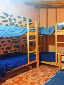 奥兰太坦波Sacred Point的客房设有三张双层床,配有蓝色床单