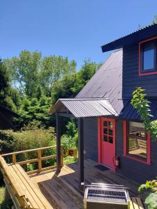 弗鲁蒂亚尔CIPRES Ecolodge & Spa的蓝色的房子,木甲板上设有红色的门