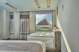 开罗Khan Duidar Inn - Pyramids View Rooftop的带浴缸和金字塔的浴室