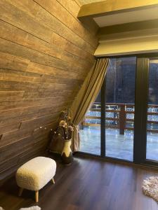 彼得罗沙尼Valea Mosului - Chic A Frame的客房设有木墙、椅子和窗户。