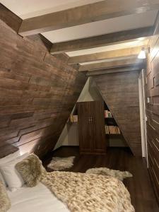 彼得罗沙尼Valea Mosului - Chic A Frame的木墙客房的一张床位