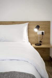卡斯托里亚Airbnb Kastoria - Bella Vista A的卧室配有白色的床和灯