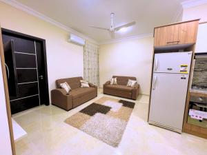 伊斯梅利亚Beach Front Apartment in Hurghada La Quinta Beach Compound的客厅配有2张沙发和冰箱