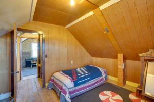 CircleCorral Creek Cow Camp Pet-Friendly Circle Cabin的卧室配有一张床铺,位于带木墙的房间内